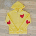 Yellow hoodie with red hearts on a textured surface