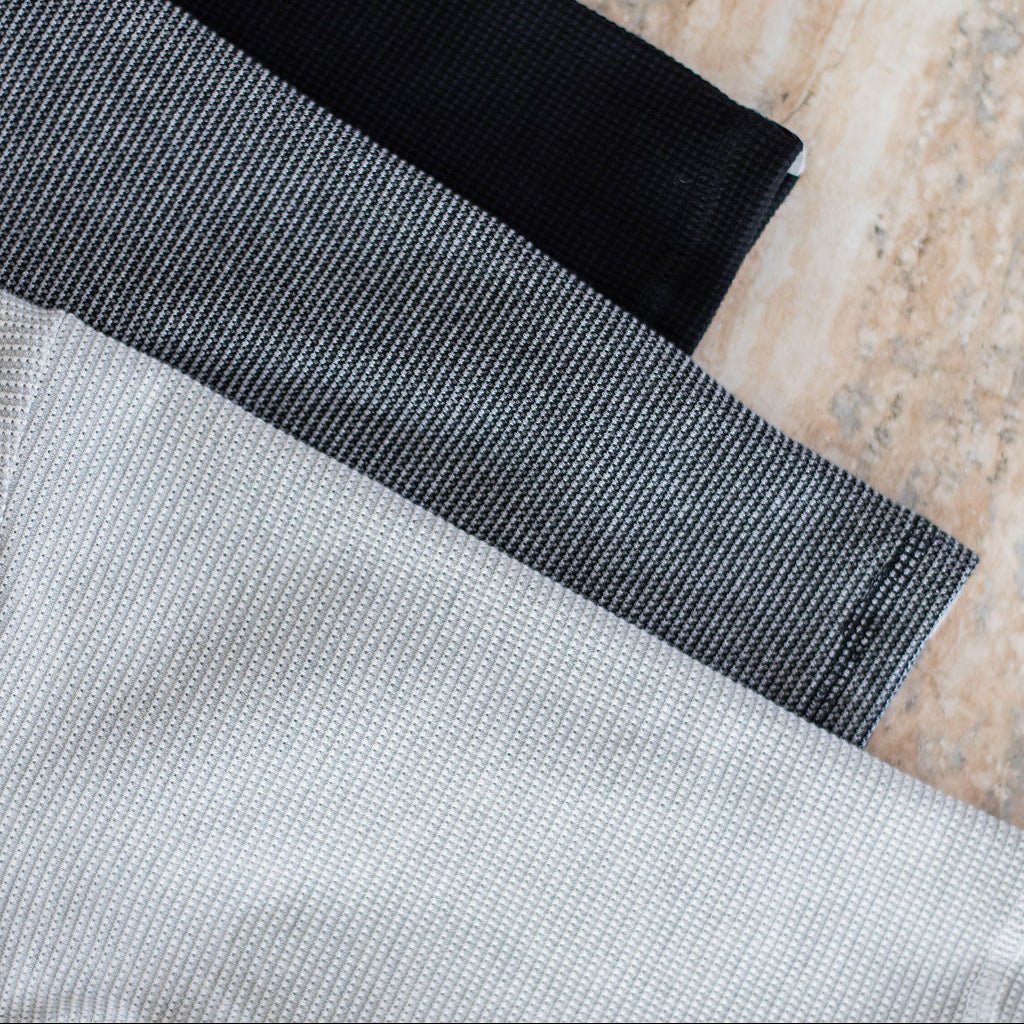 Close-up of black and gray fabric on a textured surface